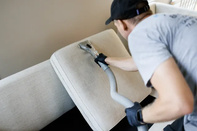 Technician extracting a sofa cushion with an upholstery tool