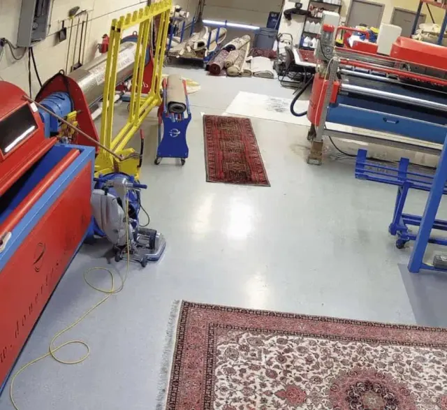 Rugs laid out on the floor of the Premier cleaning plant